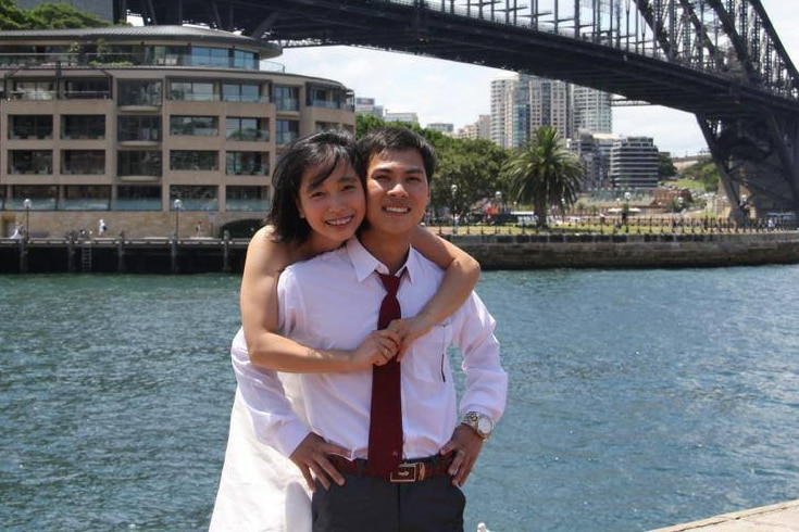 Two young people in front of Sydney Harbor Bridge