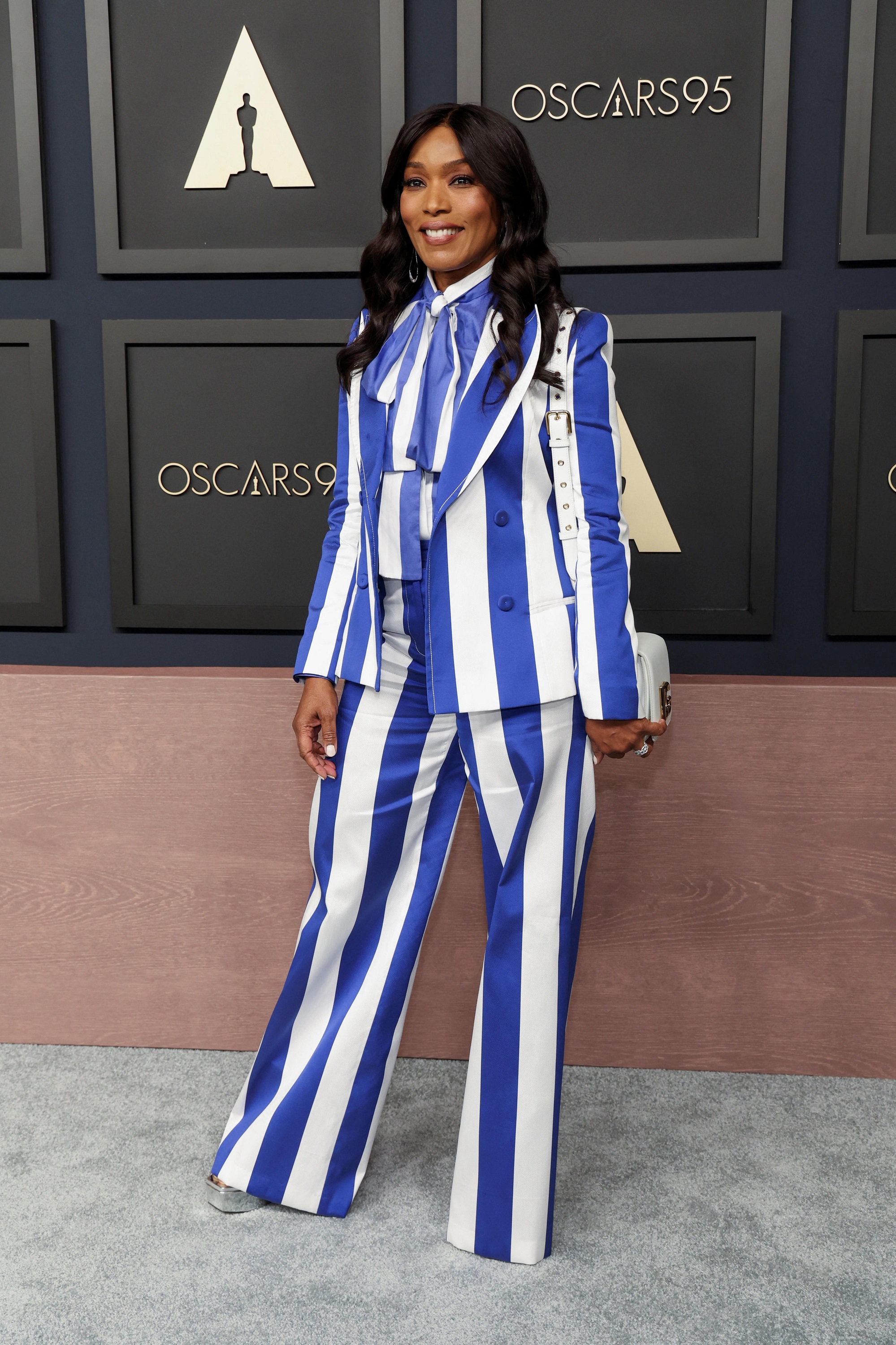 Angela Basset in a blue and white vertical striped suit. 