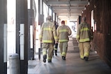 Emergency services crews walk under an awning at Martin Place, Sydney to attend to a gas leak