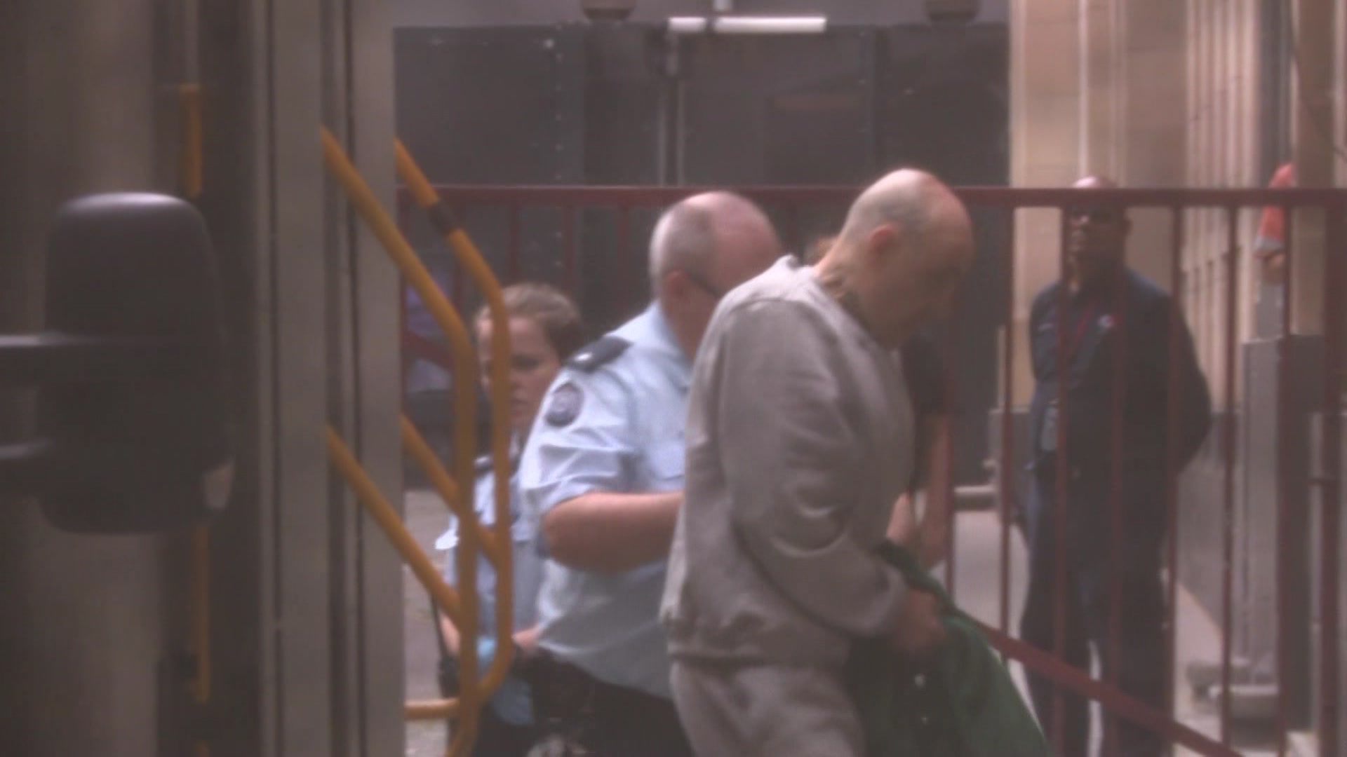 Un hombre vestido con un chándal penitenciario sale de una furgoneta penitenciaria en el Tribunal Supremo de Victoria.