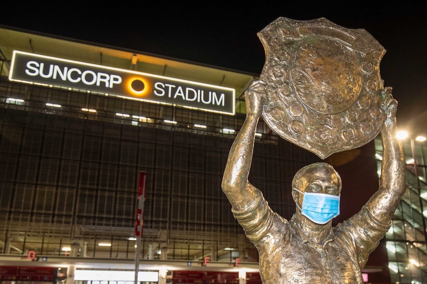 A statue of Wally Lewis in front of Suncorp Stadium (Lang Park) has a surgical face mask on it.