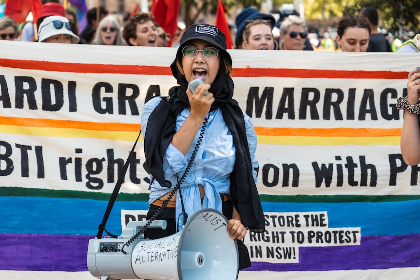 a woman holding a megaphone at a protest