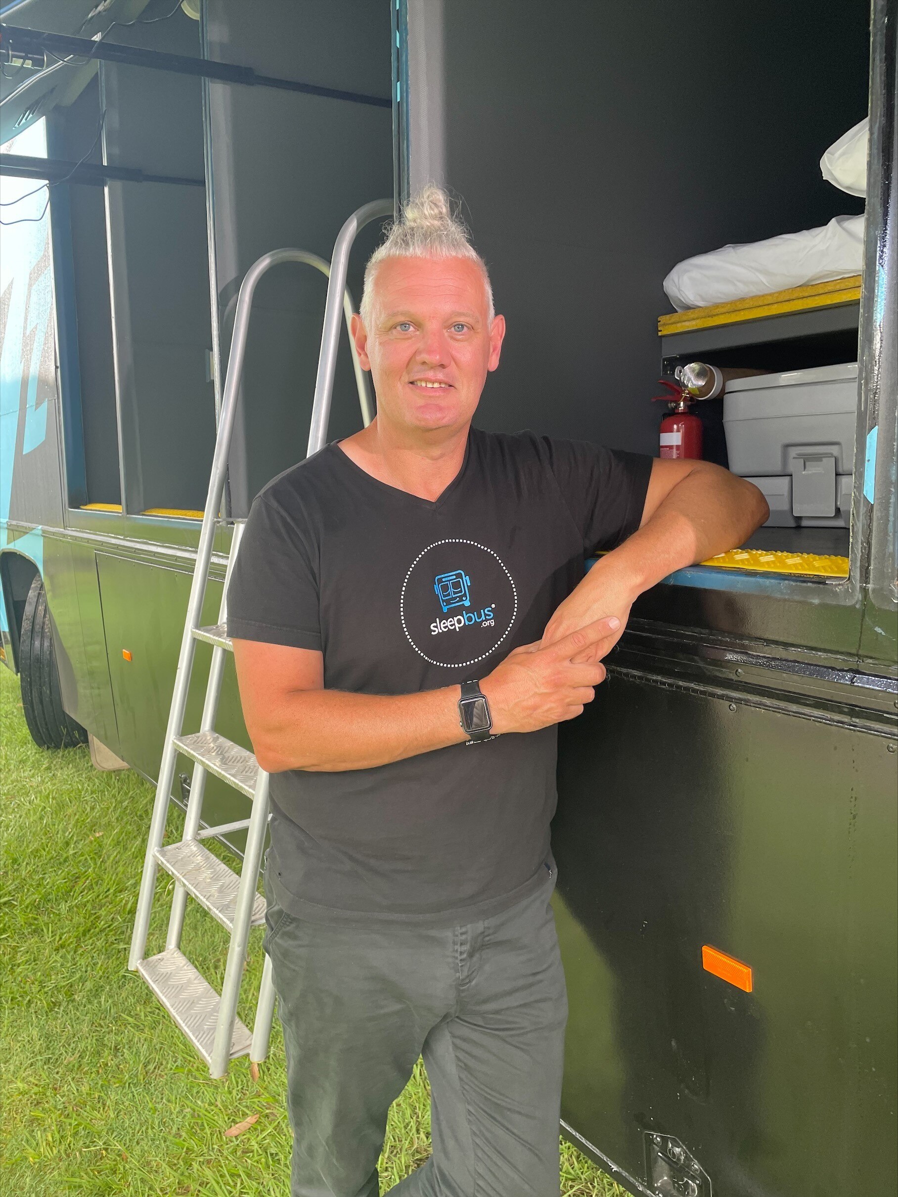 Man in black shirt, standing in front of sleep pods