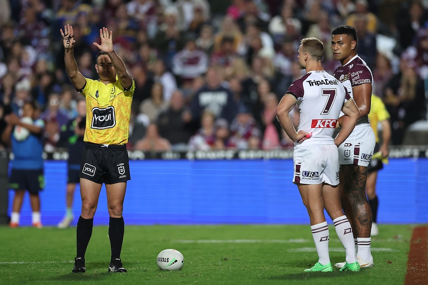NRL ref holds his hands in the air, sending a player to the sin bin