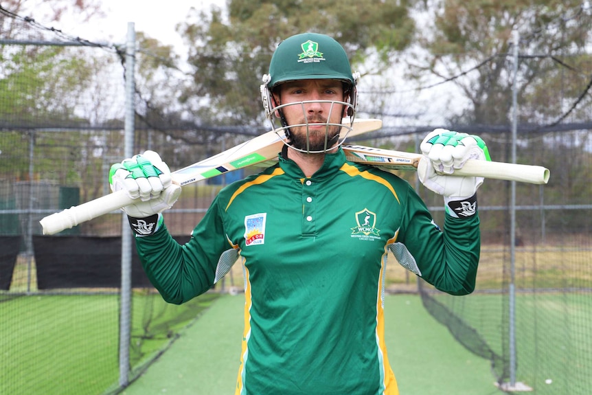 Cricketer Blake Dean holds a bat in both hands.