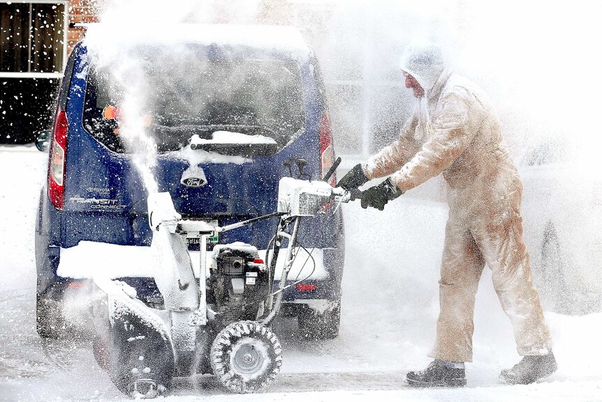 a hotel employee clears snow in Wisconsin