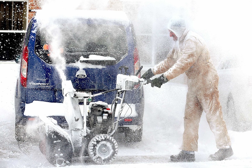 a hotel employee clears snow in Wisconsin