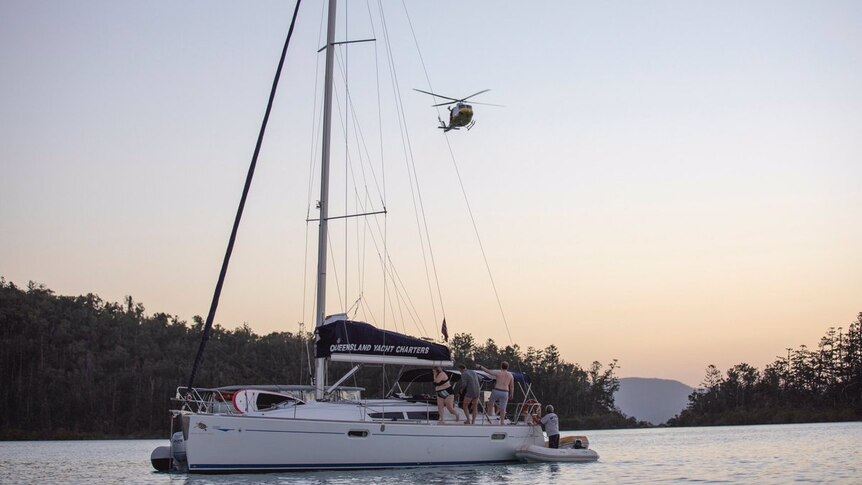 RACQ CQ Rescue helicopter hovering above the Queensland Yacht Charters boat, with people on board.