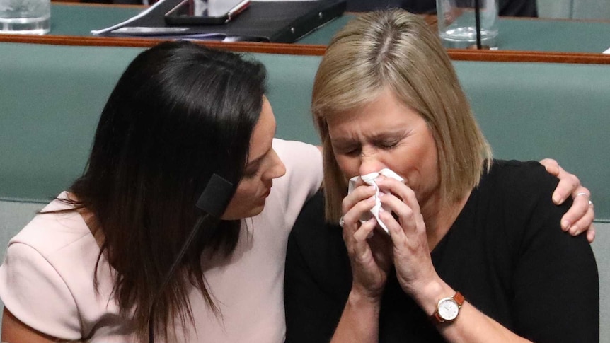 Emma Husar puts an arm around the shoulders of Susan Lamb, who is blowing her nose.