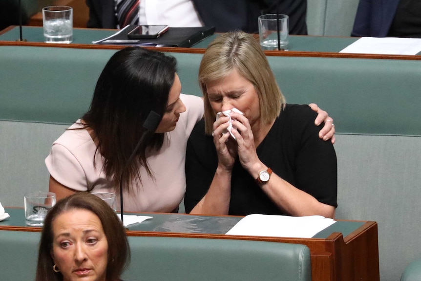 Emma Husar puts an arm around the shoulders of Susan Lamb, who is blowing her nose.