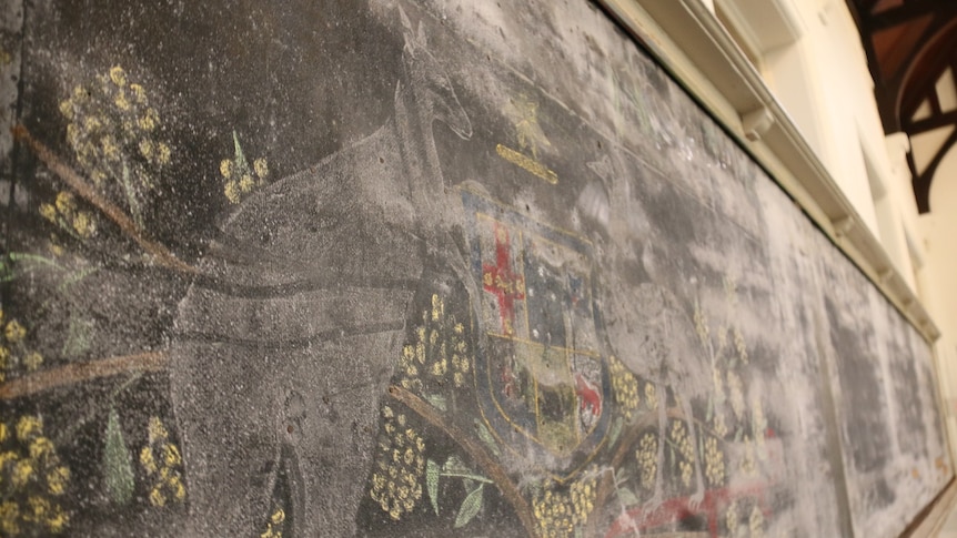 A chalk drawing of the Australian coat of arms on a chalkboard.