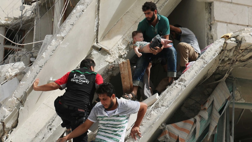 Syrian men remove a baby from the rubble of a destroyed building following a reported air strike in the Qatarji neighbourhood of the northern city of Aleppo on September 21, 2016