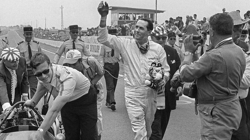 Jack Brabham waves to the crowd after winning the 1966 French Grand Prix.