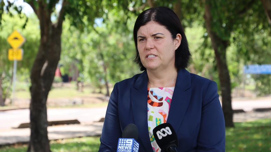 Natasha fyles stands outside wearing a navy blazer and speaking