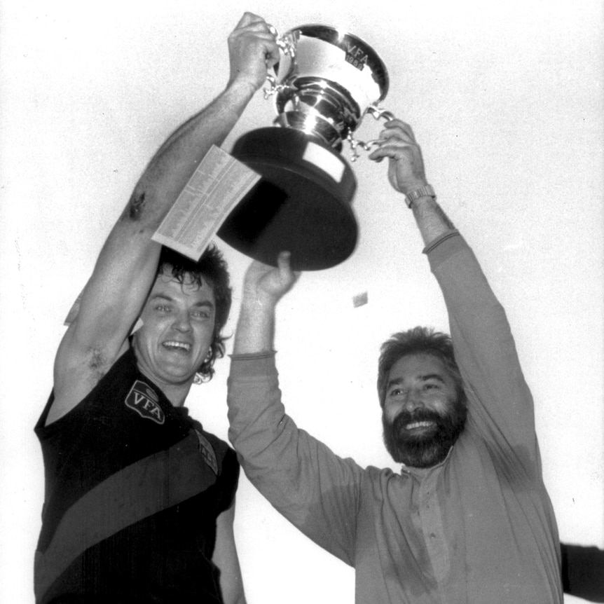 Phil Cleary holds up a trophy.