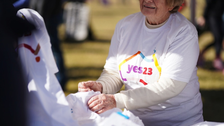 A Yes23 volunteer hands out shirts in Surry Hills' Prince Alfred Park at the Come Together For Yes rally