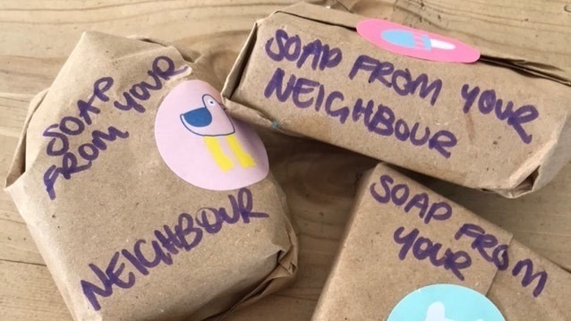 Four brown paper packages with the words "Soap from your neighbour" on them