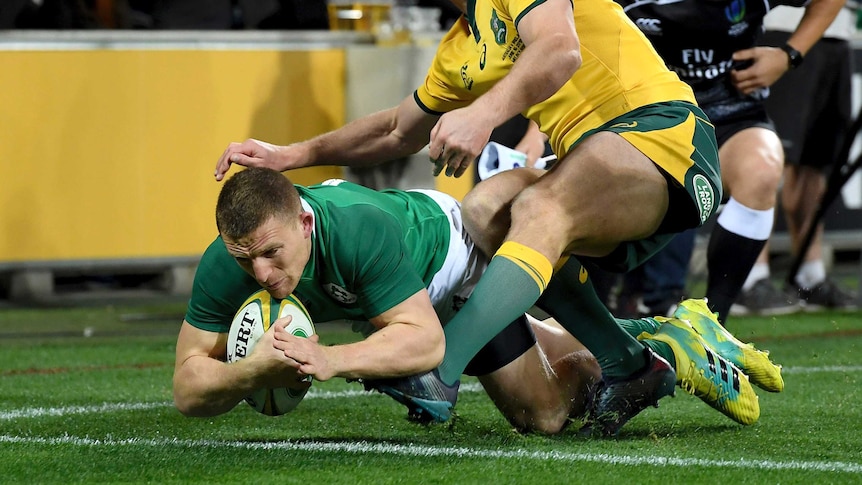 Ireland's Andrew Conway (L), scores a try against Australia in Melbourne on June 16, 2018.