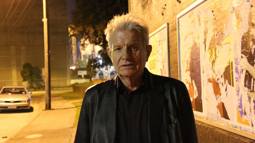 Reverend Bill Crews looks to the camera underneath a tunnel at nighttime.