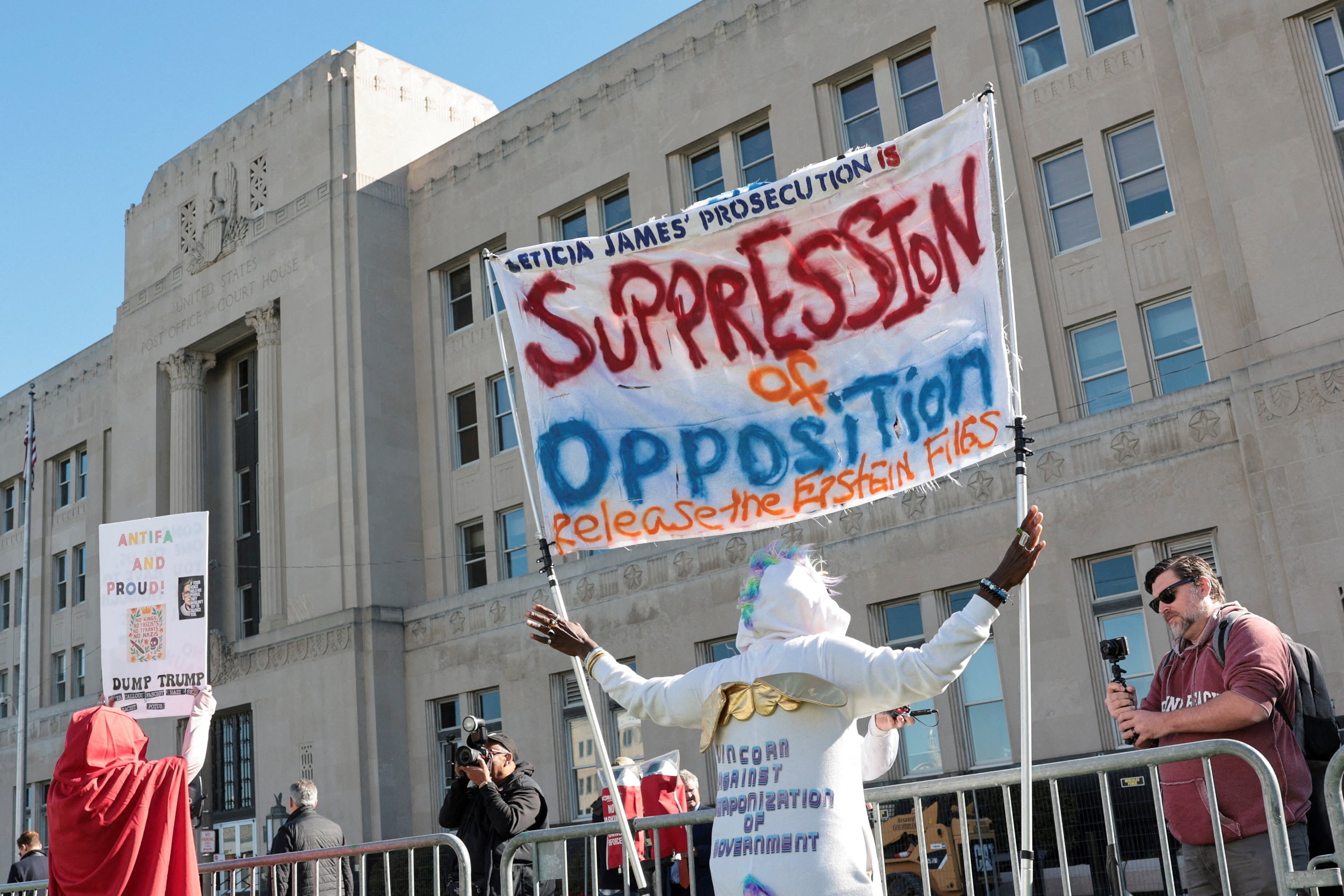 Dressed-up people hold signs read "suppression of opposition" while demonstrating outside a large court building.