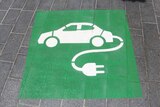 Green and white sign for charging station for an electric car parking space.