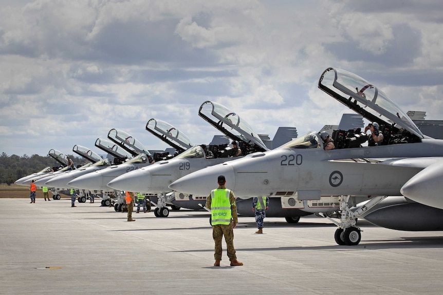 Ground crew assist as RAAF F/A-18F Super Hornets prepare for departure to the Middle East
