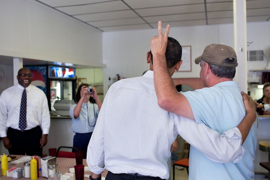 A cafe patron does bunny ears on President Barack Obama