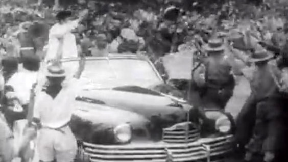 Sukarno waves to crowd from car