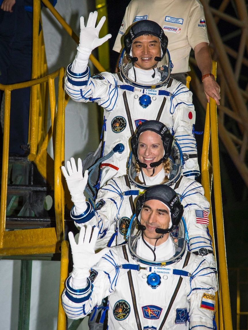 Crew members Takuya Onishi, Kate Rubins and Anatoly Ivanishin wave farewell before boarding Soyuz MS-01
