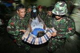 Indonesian soldiers carry an injured earthquake victim to a hospital in Bantul.