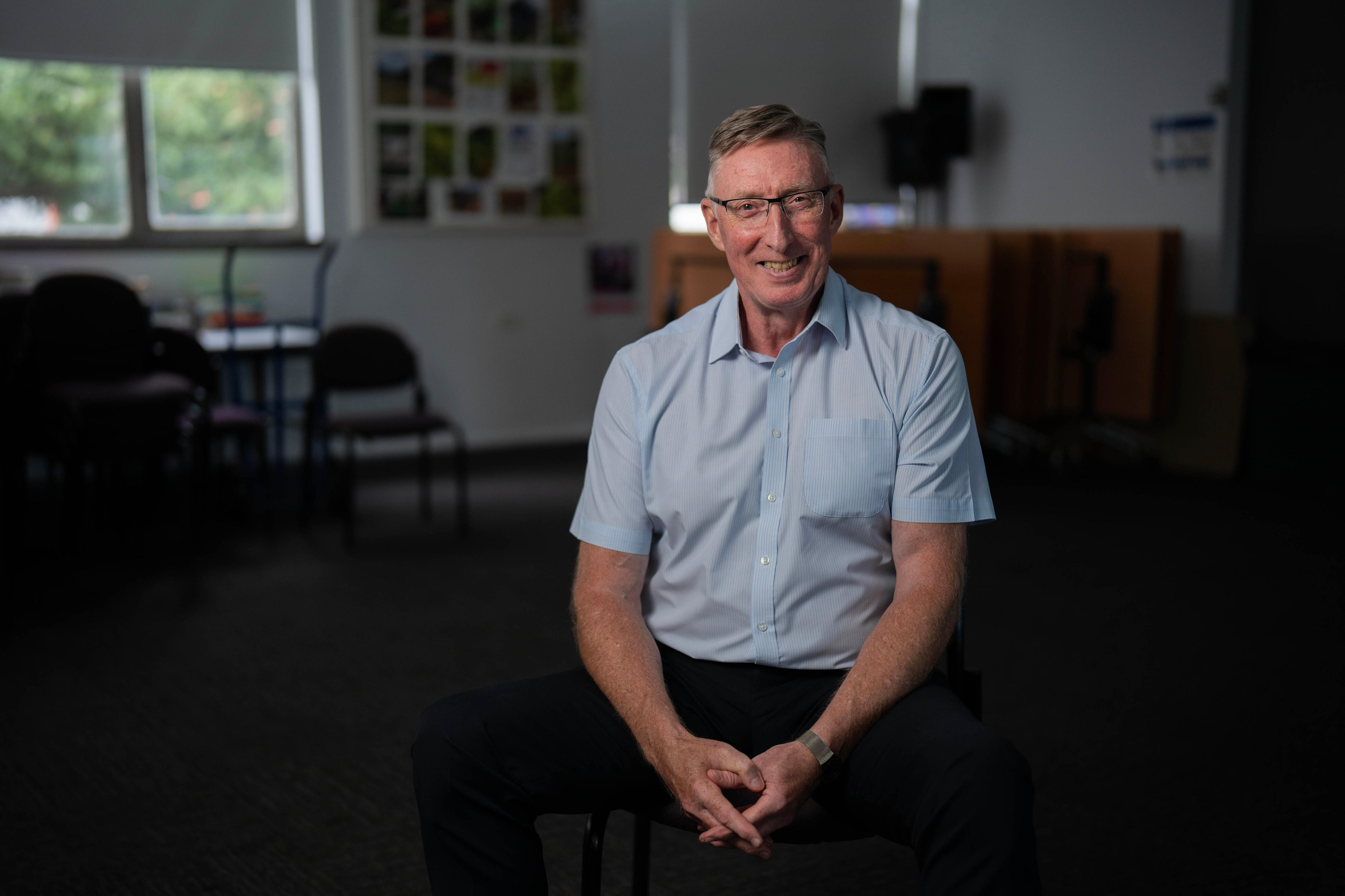Jim Mullan sonríe mientras se sienta.
