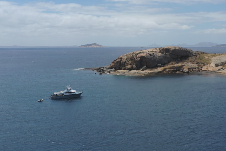 A boat on the ocean is pictured by a drone