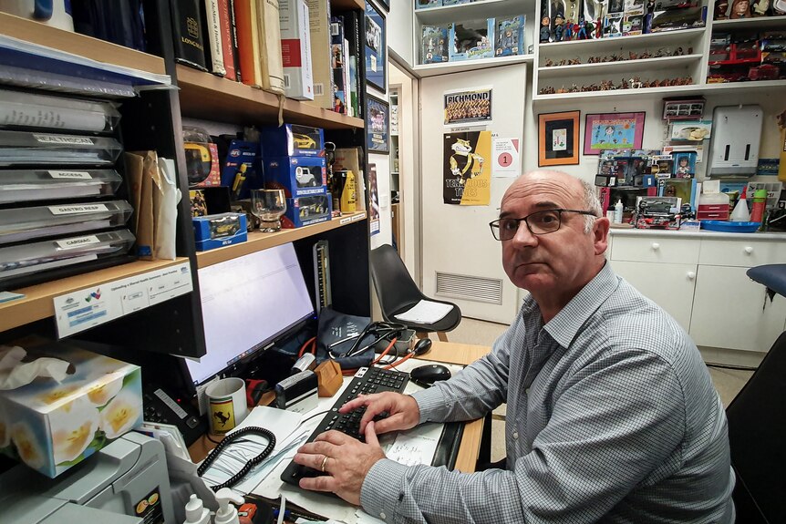 Dr Garra sits in his office, surrounded by sporting and pop culture memorabilia.