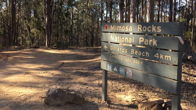 A national park sign pointing to Gillards Beach