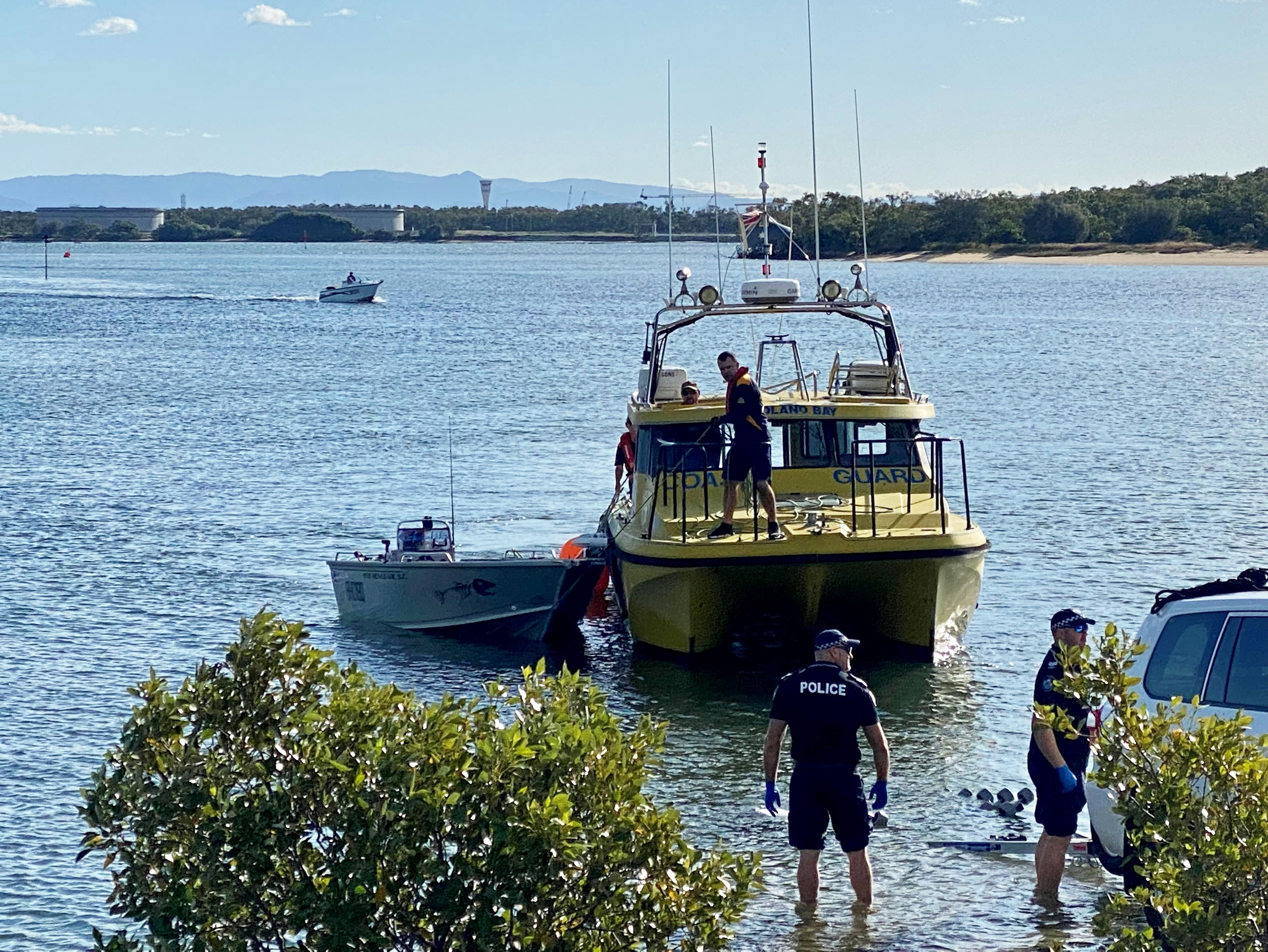 Queensland rescuers find woman's body, missing fisherman clinging to