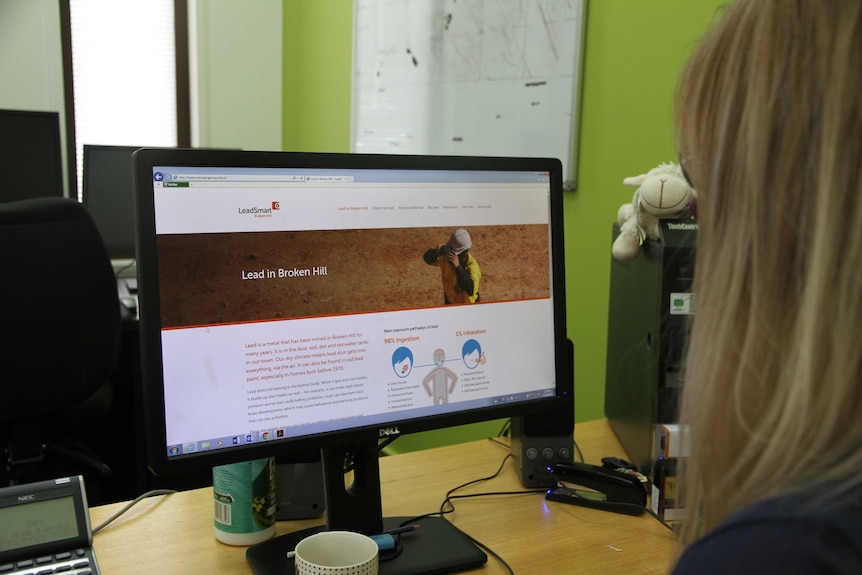 A woman looks at a computer screen that reads LeadSmart Lead in Broken Hill and information about how it is consumed