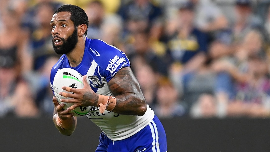 A Canterbury Bulldogs NRl player holds the ball during a match.