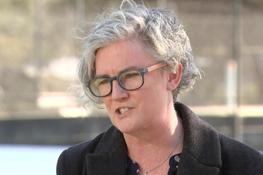 A woman with grey hair and glasses