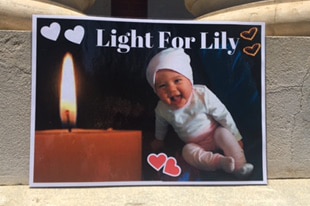 A tribute to Lily Cosgrove on the ground showing the baby girl superimposed next to a candle.