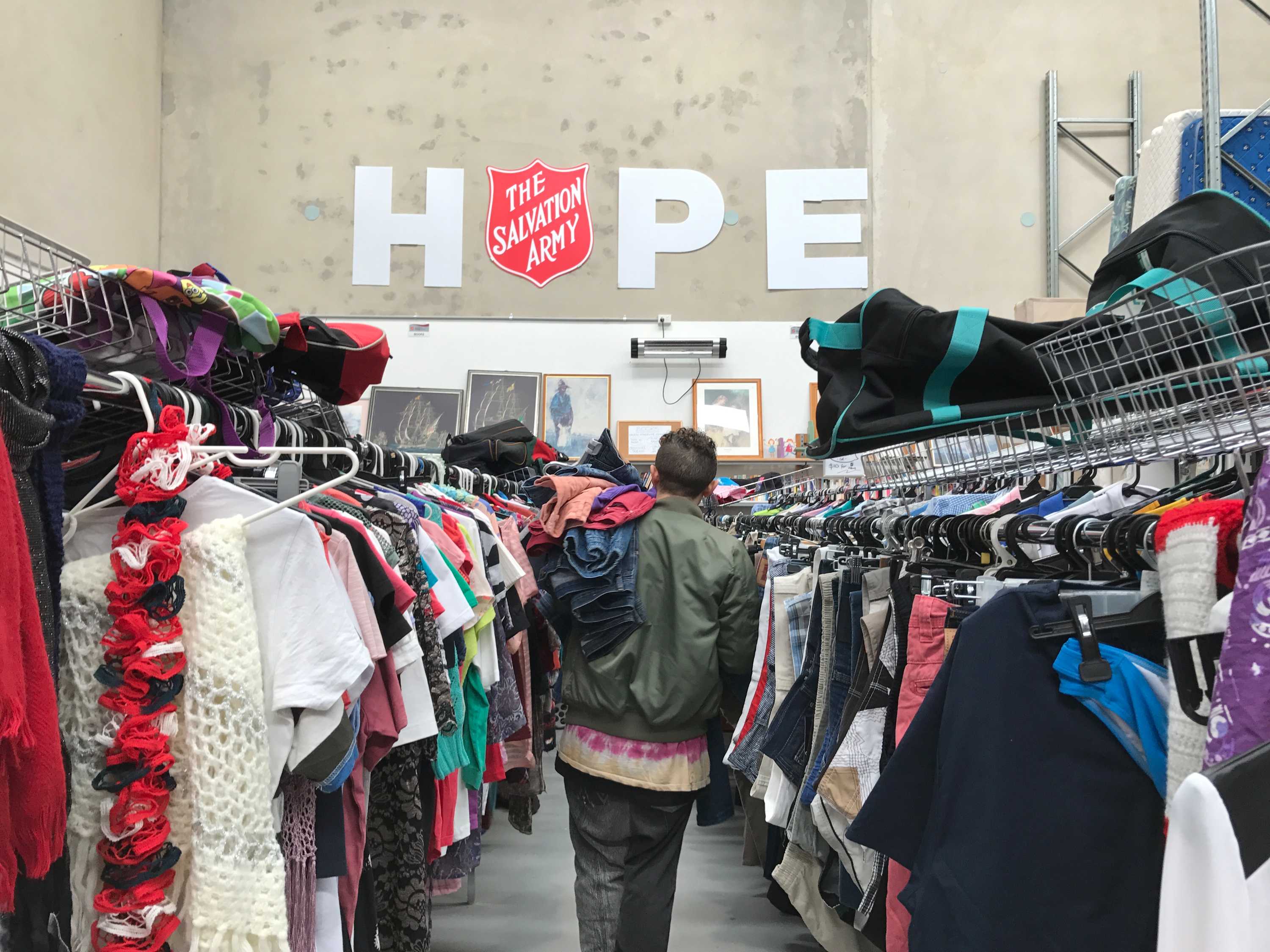 Christian Olea walks down an aisle at a Salvation Army op shop.