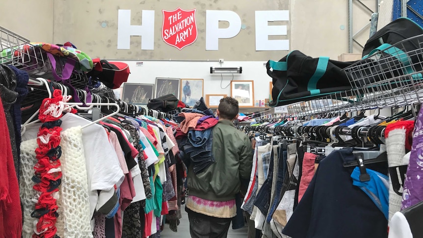 Christian Olea walks down an aisle at a Salvation Army op shop.