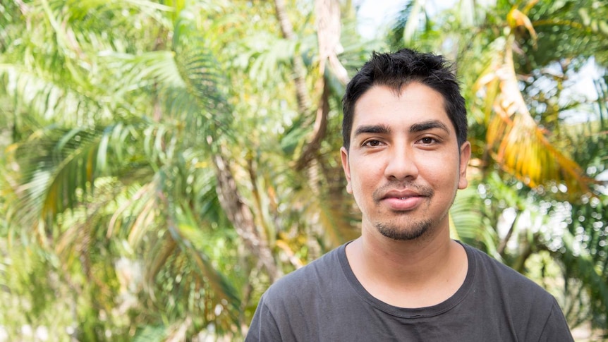 Anoj Thapa stands in front of a cluster of palm trees in Palm Cove, north of Cairns.