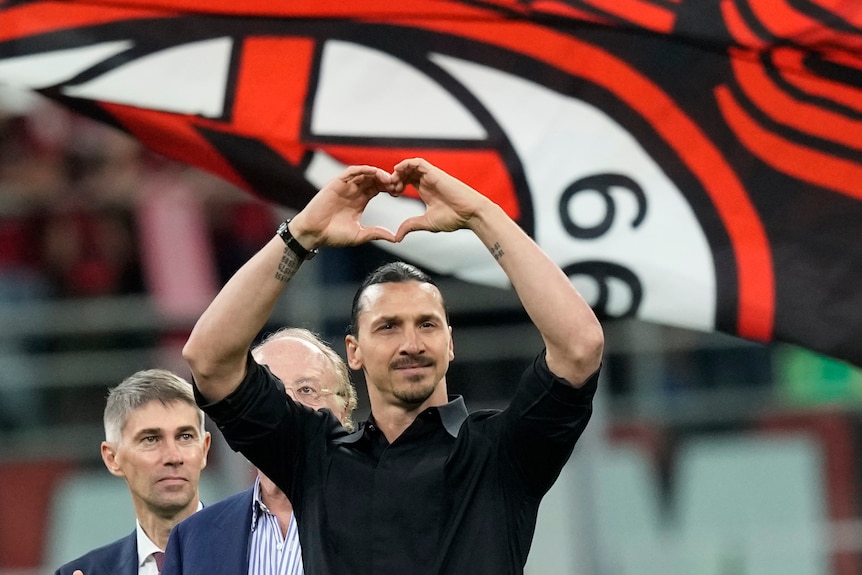 An emotional Zlatan Ibrahimović makes a heart signal with his hands to fans in Milan as he retires from football.
