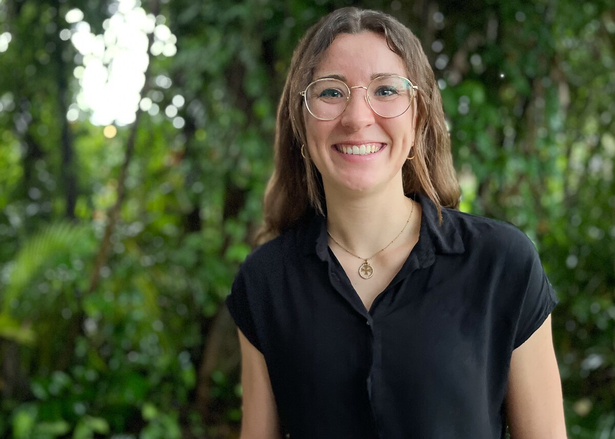 woman in dark shirt with trees in background