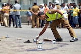 A Sri Lankan police officer examines the scene of a shooting in the capital Colombo