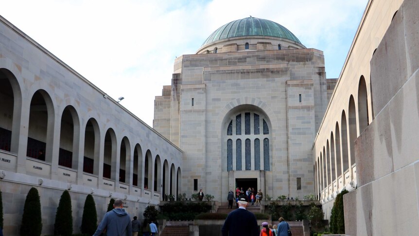 Photo of visitors walking beside Pool of Remembrance at Australian War Memorial.