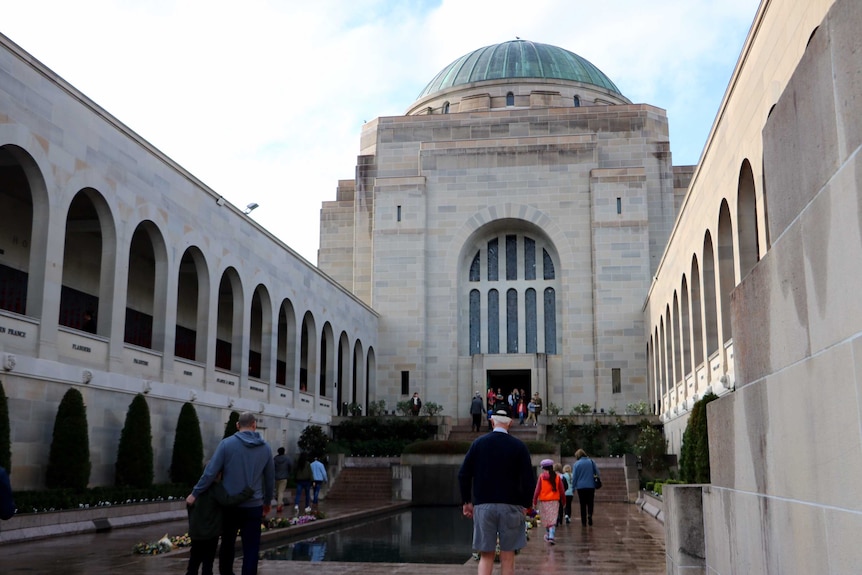 Photo of visitors walking beside Pool of Remembrance at Australian War Memorial.