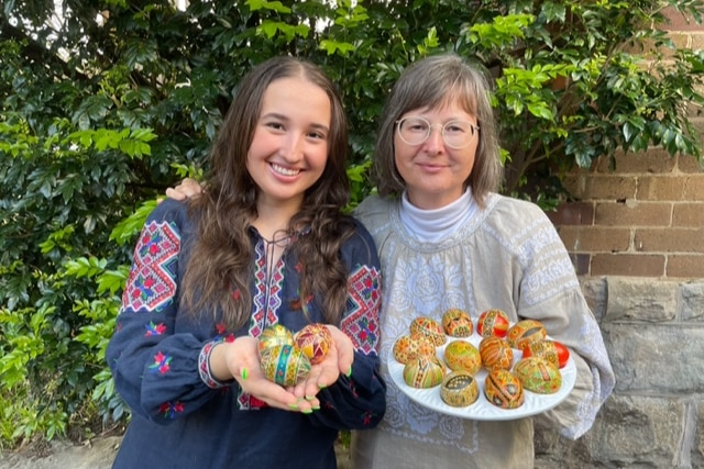 A mother and daughter show their pysanky eggs