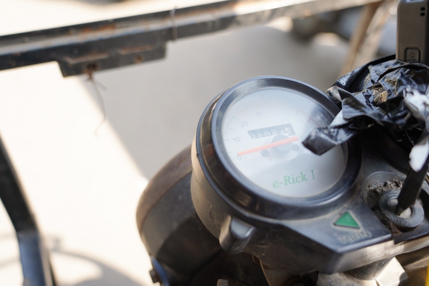 A close up of a speed dial on an electric vehicle displaying the number of kilometres.