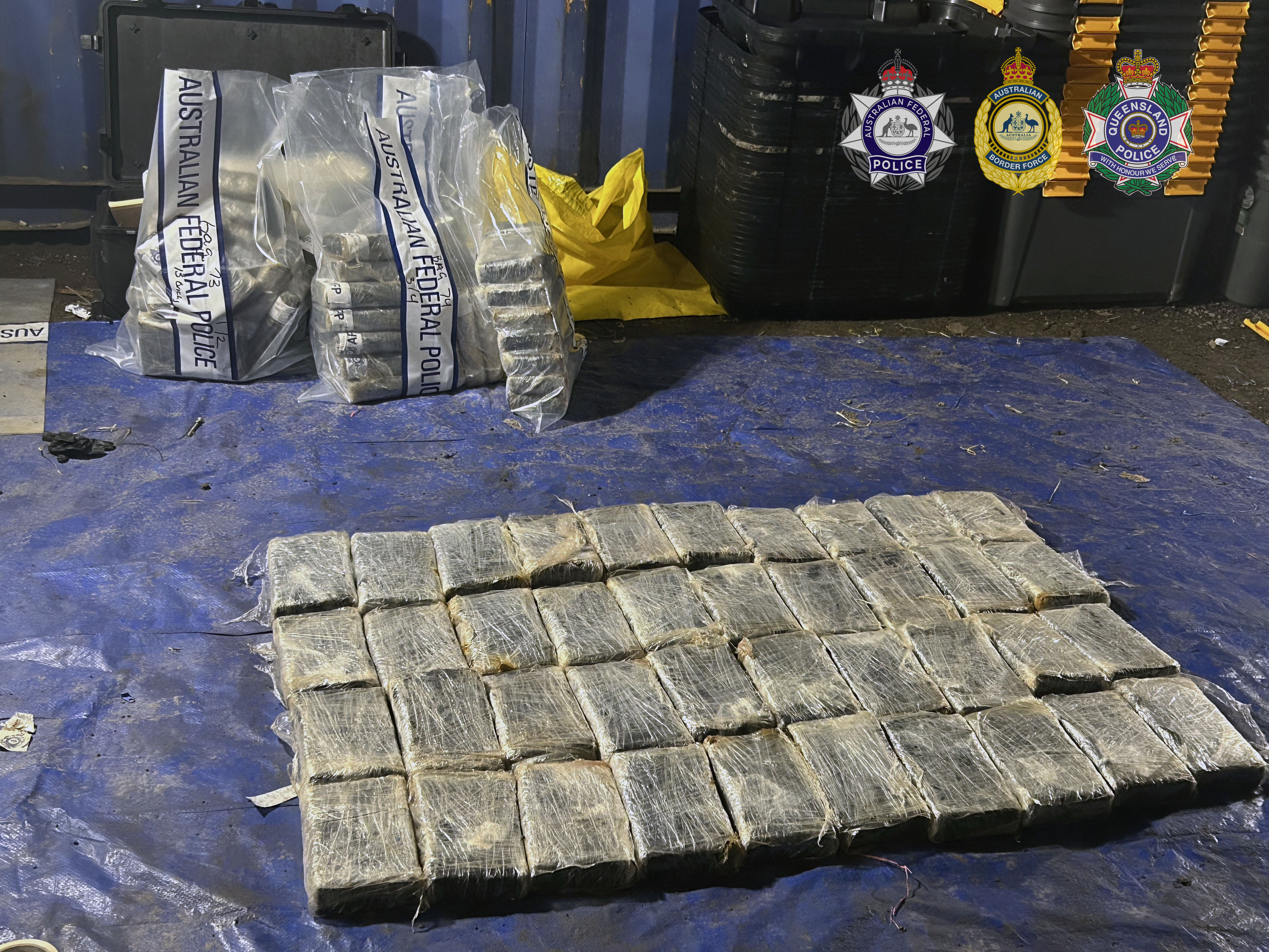 About three dozen packaged drugs lined up on a tarp.